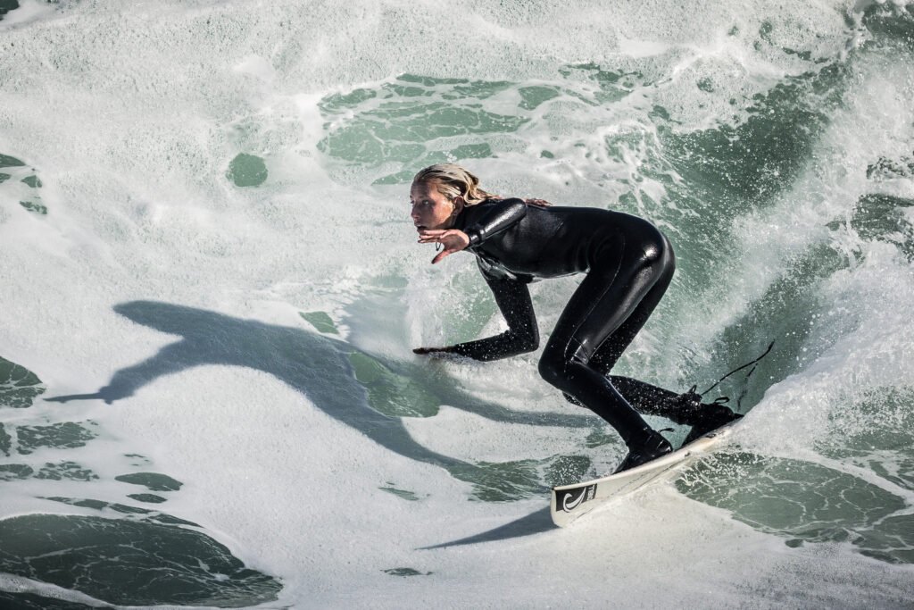 Surfer in wetsuit rides a powerful ocean wave at Steamer Lane in Santa Cruz, California