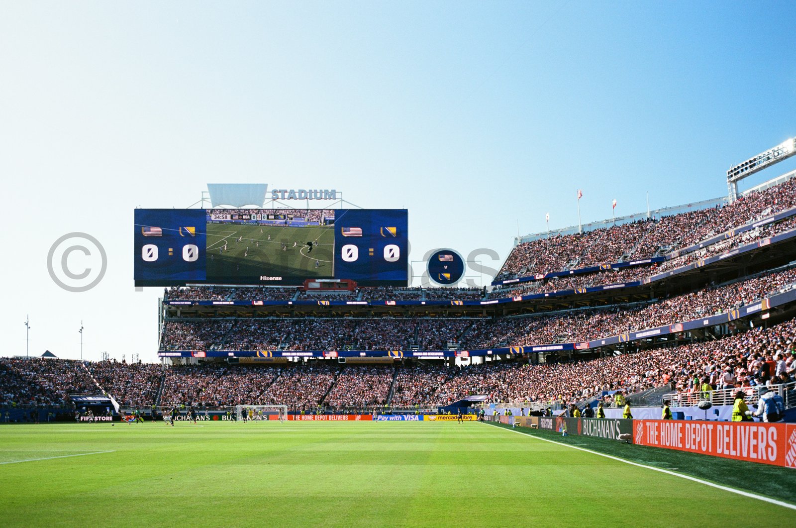Full stadium watching a soccer match under bright blue skies. Full stadium watching a soccer match under bright blue skies.