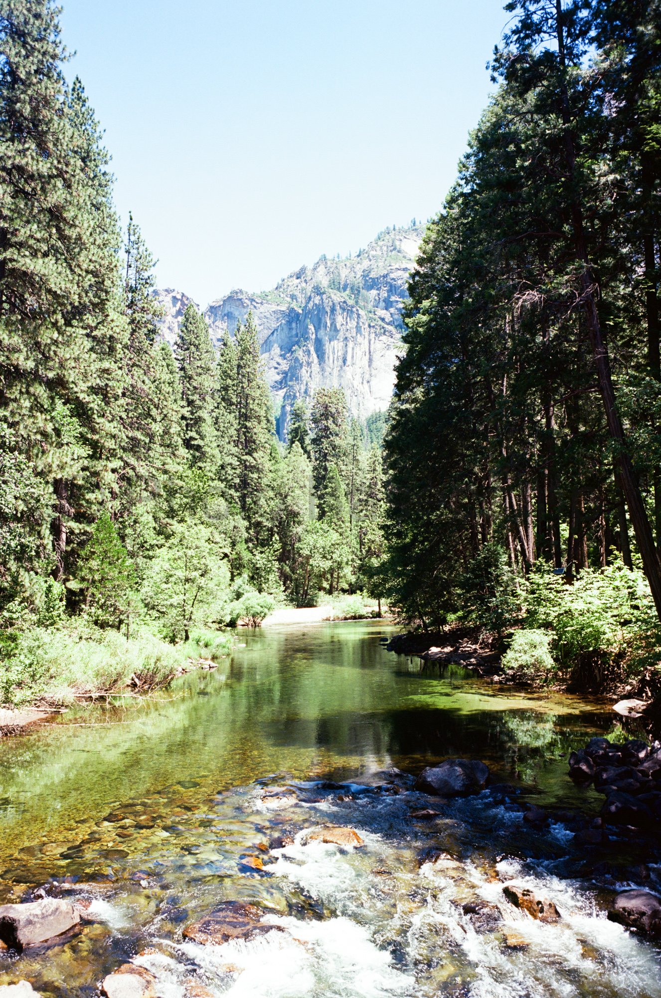 Scenic view of Merced River and granite cliffs in Yosemite Valley captured on 35mm film Scenic view of Merced River and granite cliffs in Yosemite Valley captured on 35mm film